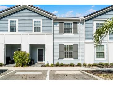 Charming two-story townhome with light blue siding and neat landscaping offers a welcoming curb appeal at 7509 Oak Spring Ln, Davenport, FL 33837