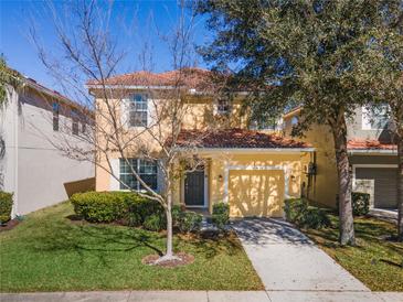 Charming two-story home features an attached garage, well-manicured lawn, and a classic tile roof at 8961 Cuban Palm Rd, Kissimmee, FL 34747