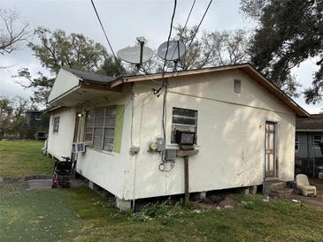 Exterior view of a one-story home with a white stucco finish and a weathered roof at 2219 W Pine St, Orlando, FL 32805