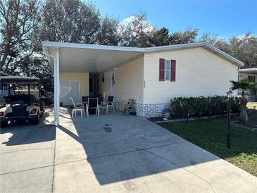 Charming home with a covered carport, outdoor seating, and well-maintained landscaping for relaxing and entertaining at 239 Sue Ave, Davenport, FL 33897