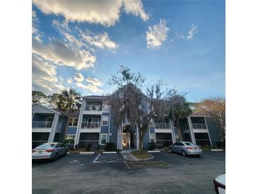 A well-maintained condominium complex shows serene blue exteriors and convenient parking spots at 2516 Grassy Point Dr # 206, Lake Mary, FL 32746