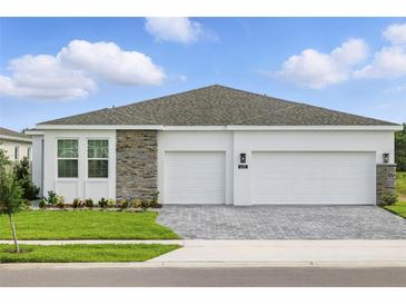 Charming single-Gathering home featuring a two-car garage, stone accents, and a well-manicured lawn at 4110 Gooseberry Trl, Kissimmee, FL 34746