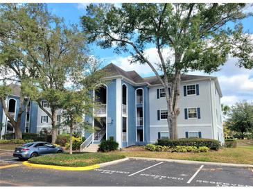 Well-maintained condo building with blue and grey exterior paint, reserved parking, and mature trees at 4304 Clubside Dr # 4304, Longwood, FL 32779