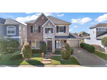 Charming two-story home featuring a mix of brick and stone with a well-manicured lawn and a two car garage at 4770 Cains Wren Trl, Sanford, FL 32771