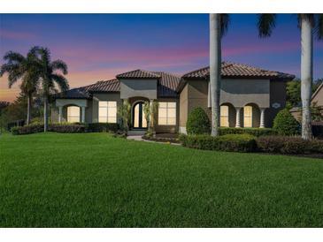 Beautiful home featuring a tile roof, lush green lawn, and elegant landscaping, creating great curb appeal at 1384 E Lake Shore Blvd, Kissimmee, FL 34744