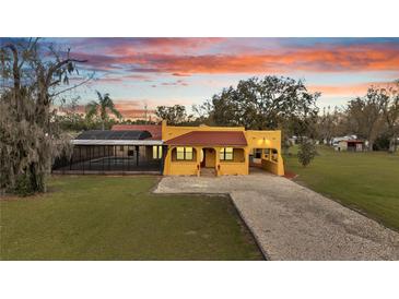 Charming home exterior featuring a screened pool and a spacious front yard and driveway at 1775 Druliner Rd, St Cloud, FL 34771