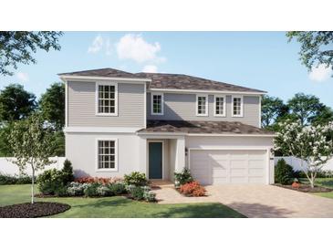 Charming two-story home with a light gray exterior, well-manicured lawn, and beautiful landscaping at 1779 Columbus Path, St Cloud, FL 34771