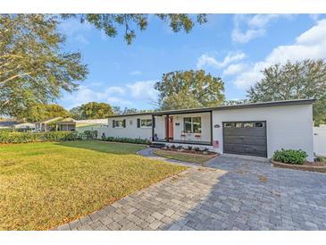 Charming single-story home with a well-manicured lawn, brick driveway, and inviting front porch at 3100 Nancy St, Orlando, FL 32806