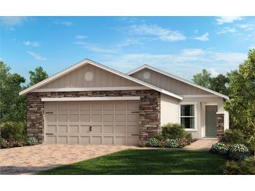 Charming single-story home with a two-car garage, stone accents, and a well-manicured front lawn at 323 Sequoia Dr, Lake Wales, FL 33859