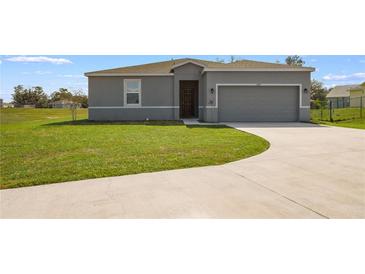 Charming single-story home featuring a well-manicured lawn and a two-car garage with a concrete driveway at 429 Ohio Way, Kissimmee, FL 34759