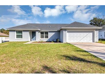 Charming single-story home with a well-manicured lawn, neutral exterior paint, and a two-car garage at 7139 Se 122Nd Ln, Belleview, FL 34420