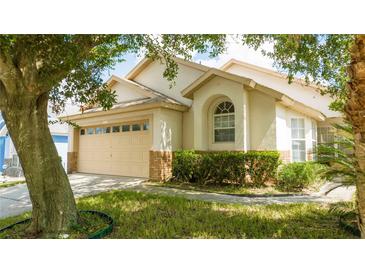 Charming single Gathering home featuring an attached two-car garage and well maintained landscaping at 8095 Indian Creek Blvd, Kissimmee, FL 34747