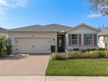 Charming single-story home featuring a brick driveway, landscaped yard, and neutral color palette at 17826 Blazing Star Cir, Clermont, FL 34714