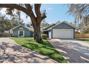 Charming single-story home with a well-maintained yard and a brick paver driveway leading to an attached two-car garage at 4515 Sea Biscut Ct, Orlando, FL 32818