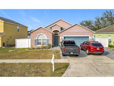 Charming single-Gathering home with a manicured front yard, a blue door, and a two-car garage at 7214 Rex Hill Trl, Orlando, FL 32818