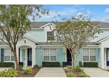 Charming townhouse with a blue exterior, well-manicured landscaping, and inviting front entrance at 7671 Otterspool St, Kissimmee, FL 34747