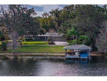 Beautiful waterfront home with lush landscaping and a private boat dock at 1100 S Lake Sybelia Dr, Maitland, FL 32751