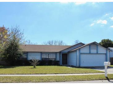 Charming single-story home with attached garage, blue trim, and a well-maintained front lawn at 1542 Colony Ave, Kissimmee, FL 34744