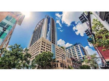 A view of the exterior of a high-rise building on a bright, sunny day at 155 S Court Ave # 2904-Penthouse, Orlando, FL 32801