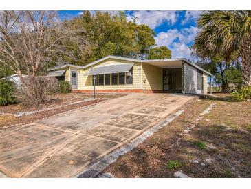 Charming single-story home featuring a long driveway and inviting curb appeal at 1765 W Schwartz Blvd, Lady Lake, FL 32159