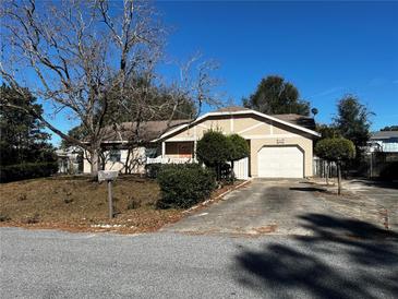 Charming single-story home features a well-manicured lawn, mature trees, and a classic exterior design at 26 Palm Run, Ocala, FL 34472