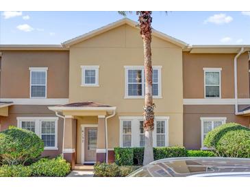 Townhome with a tan and brown exterior, complete with landscaping and a tall palm tree in the front yard at 6132 Saint Julian Dr, Sanford, FL 32771