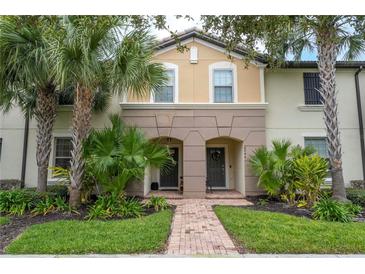 Charming townhome with a brick walkway, lush landscaping, and a welcoming entryway at 8948 Adriatico Ln, Kissimmee, FL 34747