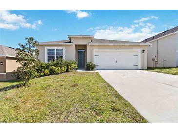 Inviting single-story home featuring a well-maintained lawn and a convenient two-car garage at 9537 Black Walnut Dr, Clermont, FL 34715