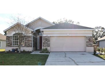 Charming single-story home with stone accents and a well-manicured lawn at 1746 Golfview Drive, Kissimmee, FL 34746