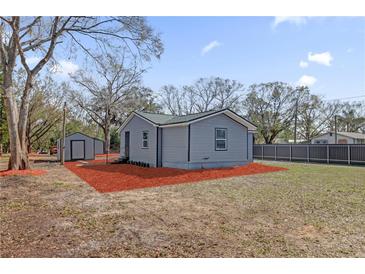 Charming home exterior featuring a gray siding, matching shed, and spacious yard at 204 Brooks Rd, Frostproof, FL 33843