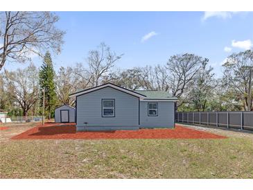 Charming home exterior featuring gray siding, a matching shed, and spacious backyard at 204 Brooks Rd, Frostproof, FL 33843