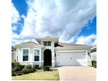 Charming single-story home with a two-car garage and a well-manicured lawn under a cloudy sky at 2132 Limestone Trl, Kissimmee, FL 34747