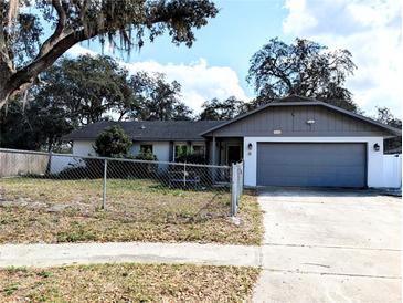 Charming single-story home with a well-maintained lawn and a classic design, featuring an attached garage and mature landscaping at 9436 Montello Dr, Orlando, FL 32817