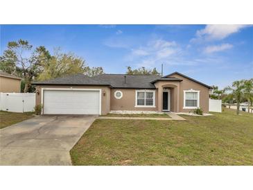 Charming one-story home with a two-car garage and a well-manicured lawn at 112 Lake Butler Ave, Haines City, FL 33844