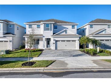 Beautiful two-story home with a well-manicured front yard, brick driveway, and a two car garage at 300 Burma St, Kissimmee, FL 34747