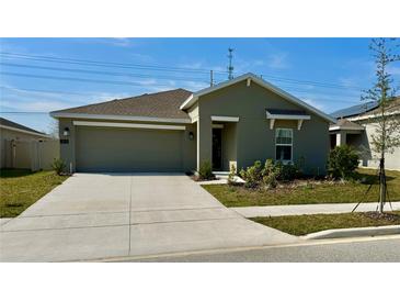 Charming one-story home featuring a well-manicured lawn and attached two-car garage at 313 Estates Ct, Haines City, FL 33844