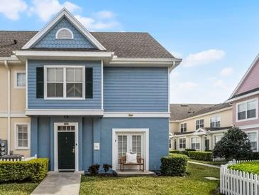 Charming blue two-story townhouse with a cozy front porch bench and well-manicured landscaping at 4008 San Gallo Dr # 102, Kissimmee, FL 34741