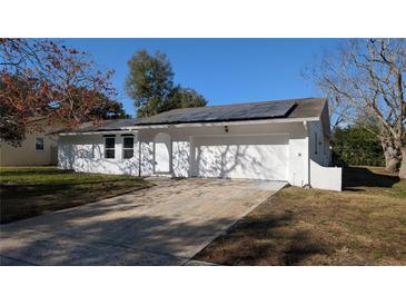 Bright exterior of home featuring a large driveway and a two-car garage door at 50 Avalon Ct, Casselberry, FL 32707