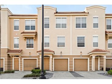 Charming townhome exterior featuring a two-car garage and well-maintained landscaping at 5076 Tideview Cir # 90, Orlando, FL 32819