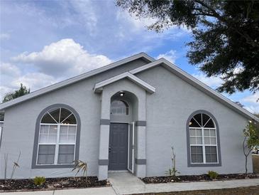 Charming single-story home featuring arched windows, gray exterior, and a well-manicured front yard at 513 Seasons Ct, Winter Springs, FL 32708