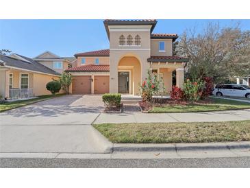 Charming two-story home featuring a tiled roof, arched entryway, and beautiful landscaping at 583 Treehouse St, Winter Springs, FL 32708