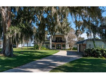 Inviting two-story home with well-manicured lawn, mature trees, and a private driveway at 9575 Ne 306Th Ct, Fort Mc Coy, FL 32134