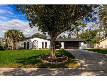 Charming single-story home with well-maintained lawn and elegant curb appeal, showcasing mature landscaping at 2555 Sweetwater Trl, Maitland, FL 32751