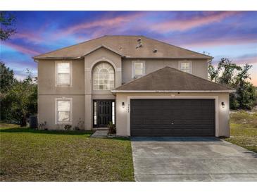 Two-story home features an attached two car garage and well maintained lawn at 2645 Coachman Dr, Deltona, FL 32738