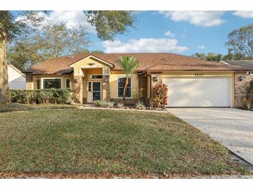 Charming single-story home featuring a well-manicured lawn and an attached two-car garage at 5247 Secluded Oaks Dr, Orlando, FL 32812