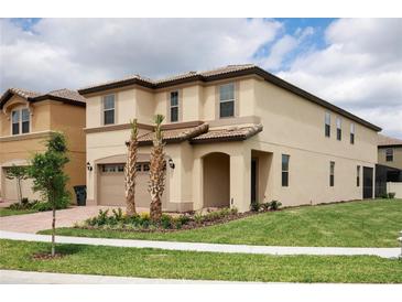 Inviting two-story home with a two-car garage, well-maintained lawn, and tiled roof at 8874 Qin Loop, Kissimmee, FL 34747