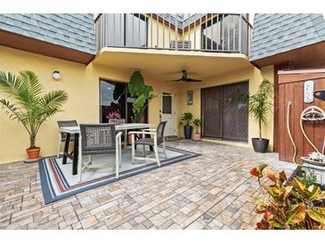 Inviting outdoor patio featuring tile flooring, a dining table, and well-maintained landscaping, perfect for entertaining guests at 90 Cedar Dunes Dr, New Smyrna Beach, FL 32169