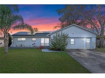 Charming single-story home featuring a lush green lawn and solar panels for energy efficiency at 9544 Brimton Dr, Orlando, FL 32817