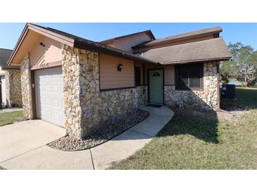 Charming home exterior features stone accents, a one car garage and a walkway to the front door at 1104 Southampton Dr # 3, Port Orange, FL 32129