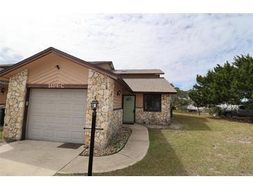 Charming single-story home with stone accents, a paved walkway, and an attached one-car garage at 1104 Southampton Dr # 3, Port Orange, FL 32129